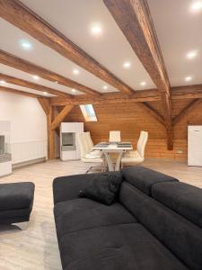 un soggiorno con un divano nero e un tavolo di Zentrale Erbendorfer Studiowohnung a Erbendorf Altre 8 foto