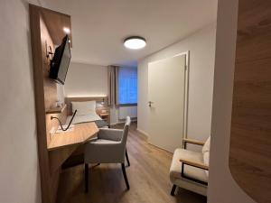 una camera d'albergo con scrivania e una camera con letto di Haus Luise a Bad Hindelang