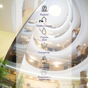 敖德萨GRAND OTRADA Hotel Resort & SPA的建筑物内的螺旋楼梯，上面有标识。