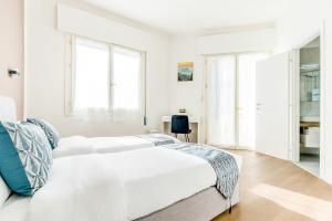 a white bedroom with a large bed and windows at Ipin Home in Mestre