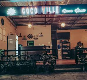 a person sitting in front of a coffee shop at CocoVille Guesthouse Barkada Room in Alegria