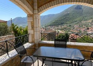 a table and chairs on a balcony with a view at Panorama Stonehouse in Leonidio