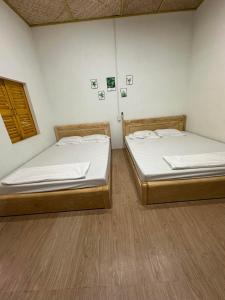 two beds sitting in a room with at Homestay Dat Phu in Tuy Hoa