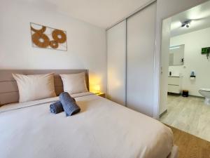 a bedroom with a large white bed and a bathroom at Le Silvestre in Bouliac