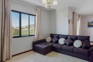 a living room with a couch and a large window at Estrela House I Calheta Madeira in Calheta