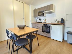 a kitchen with a table and chairs in a room at Le Silvestre in Bouliac