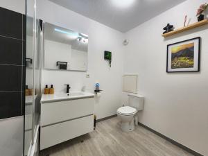 a white bathroom with a toilet and a sink at Le Silvestre in Bouliac