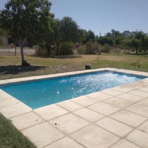 a swimming pool with blue water in a yard at Plumas verde, casa campo in Médano de Oro