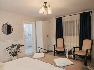 een slaapkamer met een bed, 2 stoelen en een spiegel bij Zodia Craiului in Peştera