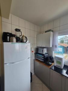 een keuken met een witte koelkast en een magnetron bij Ótimo apartamento com ampla sacada e vista pro mar in São Francisco do Sul