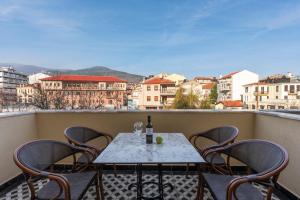 - une table et des chaises sur un balcon avec une bouteille de vin dans l'établissement Mountain Pine Luxury Suites, à Flórina