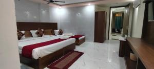 a bedroom with a large bed and a bathroom at Hotel Gloria Rishikesh in Rishīkesh