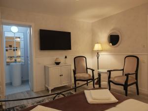 ein Wohnzimmer mit zwei Stühlen und einem Tisch und einem Fernseher in der Unterkunft Zodia Craiului in Peştera + 35 Fotos