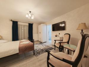 ein Hotelzimmer mit Bett, Tisch und Stühlen in der Unterkunft Zodia Craiului in Peştera