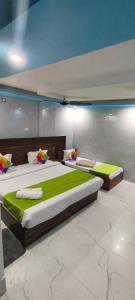 two large beds in a room with green sheets at Hotel Gloria Rishikesh in Rishīkesh