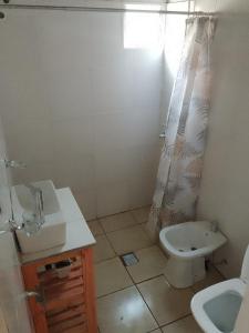 ein Badezimmer mit Waschbecken, Toilette und Dusche in der Unterkunft Depto Calamuchita Rumipal in Villa Rumipal