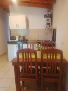 eine Küche mit einem Holztisch und 4 Stühlen in der Unterkunft Depto Calamuchita Rumipal in Villa Rumipal