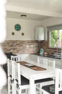 een keuken met een witte tafel en witte stoelen bij Casa de Buda Chapadmalal in Chapadmalal