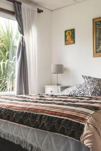 een slaapkamer met een bed en een raam bij Casa de Buda Chapadmalal in Chapadmalal