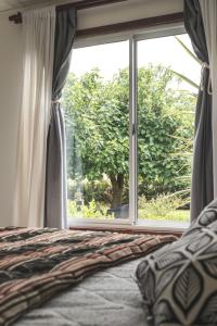 een slaapkamer met een bed en een groot raam bij Casa de Buda Chapadmalal in Chapadmalal +10 foto's