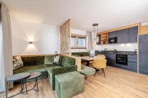a living room with a green couch and a table at my Zillernest in Zell am Ziller