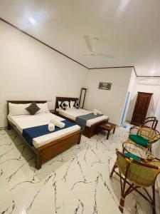 - une chambre avec 2 lits et une chaise dans l'établissement Jasmine Villa, à Bentota
