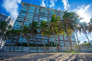 a large building with palm trees in front of it at Son de Metro Apartment - Condado Beach & Pool, Walk to Ocean in San Juan