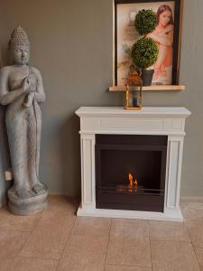 een standbeeld van een vrouw die naast een open haard staat bij La Siègià Resort spa in Massa Marittima