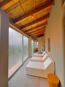 een kamer met witte bedden en grote ramen bij La Siègià Resort spa in Massa Marittima