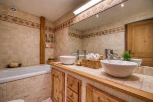 een badkamer met 2 wastafels en een bad bij Appartements dans le Chalet Nessa - Combloux in Combloux