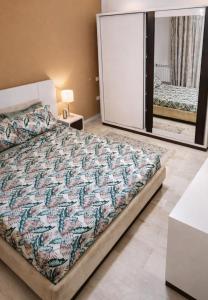 een slaapkamer met een bed en een spiegel bij Dar rahma in Tunis