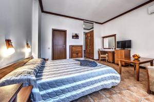 een slaapkamer met een groot bed en een bureau bij Спа Хотел Орфей in Devin