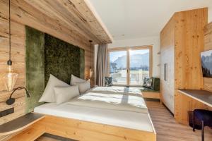 a bedroom with a large bed and a large window at my Zillernest in Zell am Ziller +74 photos