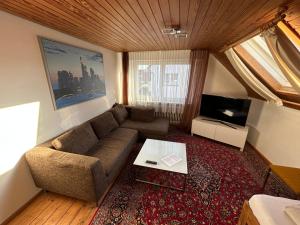 un soggiorno con un divano e una TV di Central Apartment Rödermark 3SZ a Rödermark