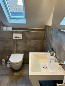 un bagno con un water e un lavandino di Central Apartment Rödermark 3SZ a Rödermark Altre 16 foto