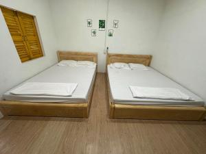 twee bedden naast elkaar in een kamer bij Homestay Dat Phu in Tuy Hoa