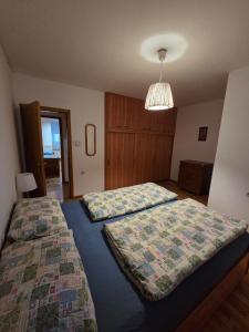 a bedroom with two beds and a chandelier at Apartment SOFI Novi Travnik in Novi Travnik