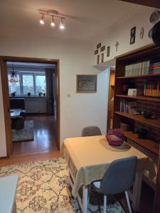 a living room with a table and chairs and a book shelf at Apartment SOFI Novi Travnik in Novi Travnik +8 photos