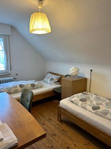 una stanza con due letti, un tavolo e una lampada di Central Apartment Rödermark 3SZ a Rödermark