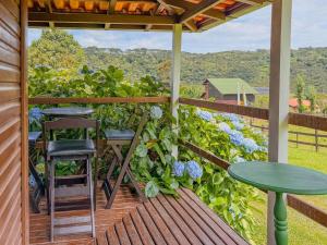 a deck with two tables and two stools at Refúgio do Vale in Urubici