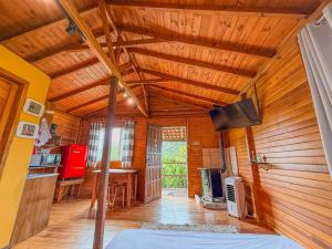 a room with a wooden ceiling with a bed and a desk at Refúgio do Vale in Urubici
