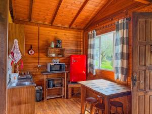 a kitchen with a red refrigerator and a table at Refúgio do Vale in Urubici