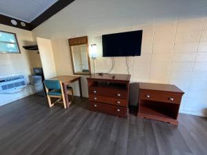 een kamer met een bureau en een tv aan de muur bij Royal inn in Quincy