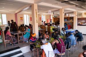 a group of people sitting at tables in a restaurant at Aryas Residency- Near Isha Foundation Coimbatore & Adiyogi statue in Alāndurai