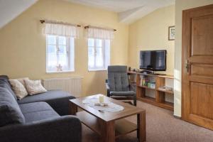 een woonkamer met een bank, twee stoelen en een tv bij Krkonošská chaloupka in Cerny Dul