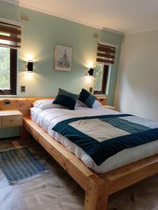 een groot bed in een slaapkamer met een houten frame bij Cabañas Los Volcanes Ensenada Puerto Varas in La Ensenada