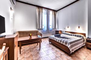 een kamer met een bed, een bank en een tafel bij Спа Хотел Орфей in Devin