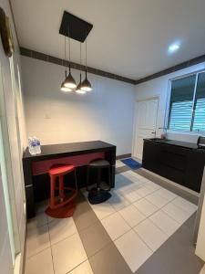 a kitchen with a desk and two stools in it at The Luxe Stay in Kuching