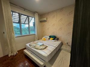 a bedroom with a bed and a window at The Luxe Stay in Kuching