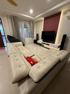a white couch in a living room with a television at The Luxe Stay in Kuching